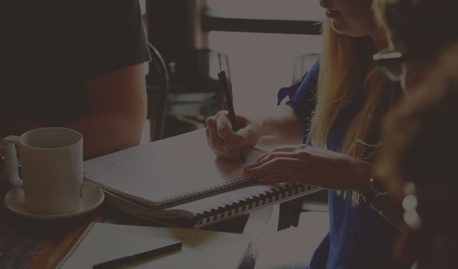 A group of people working with a notebook at a table