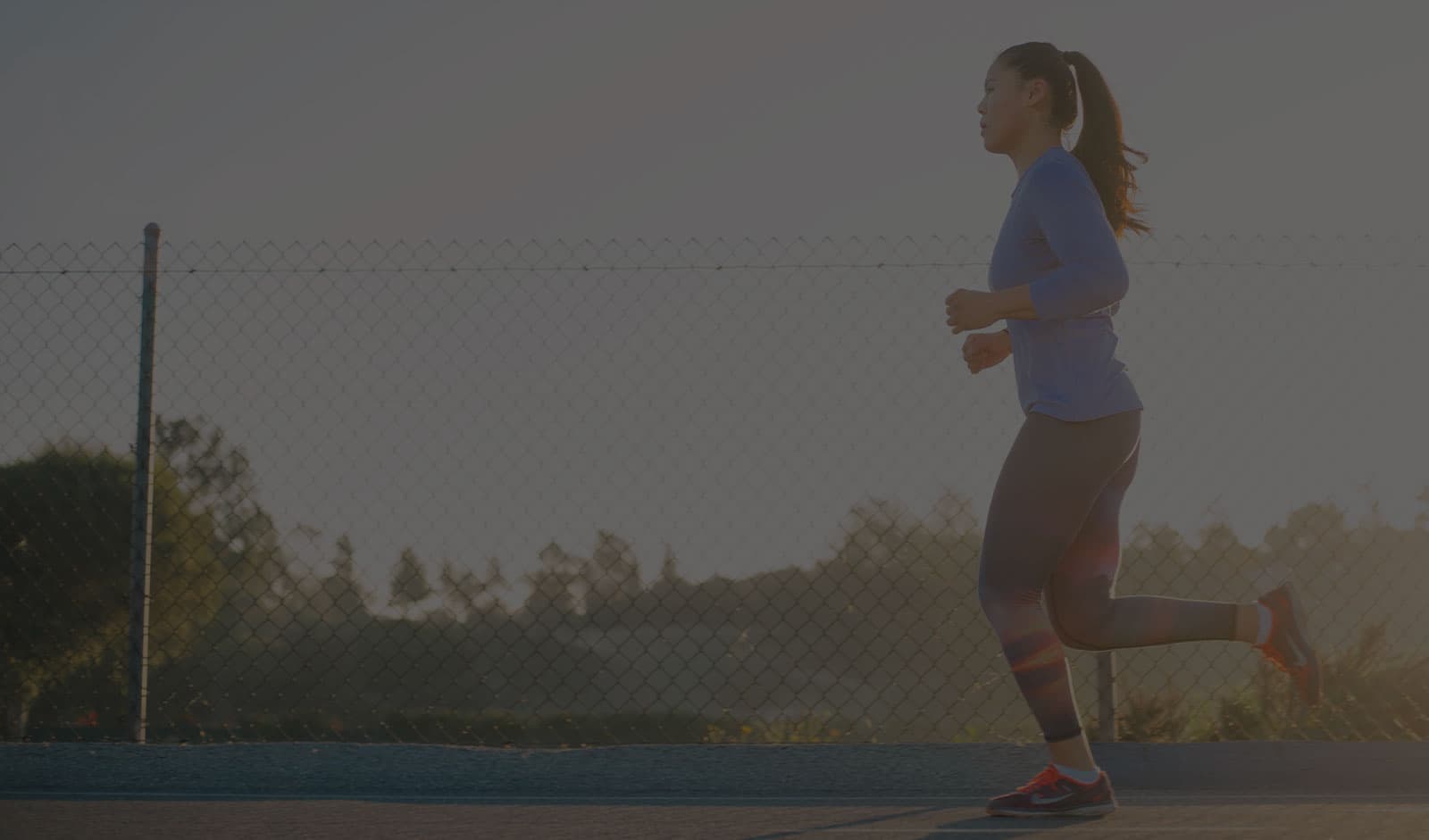 A runner jogs at sunset