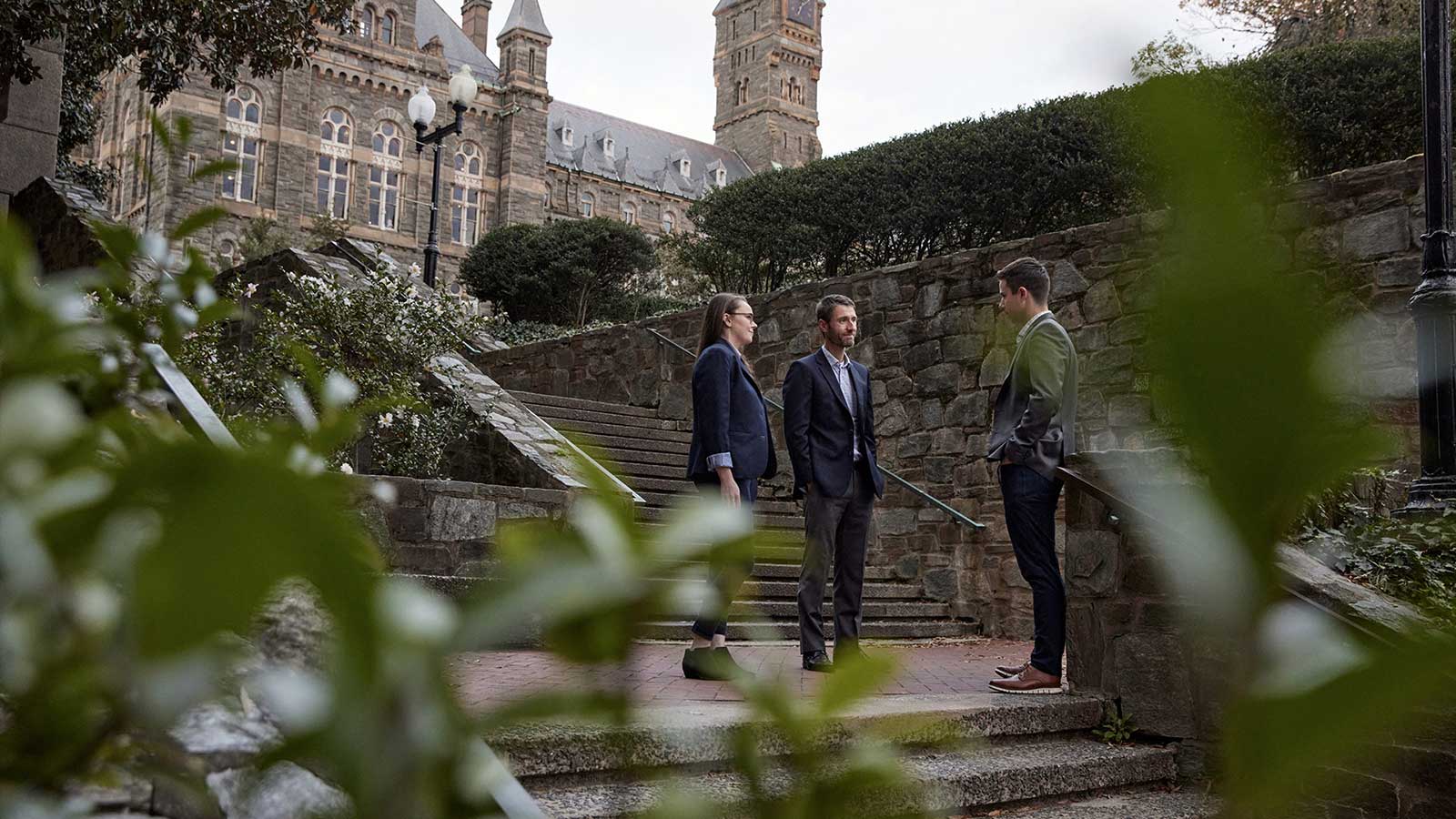 A group of people talk on a patio on campus