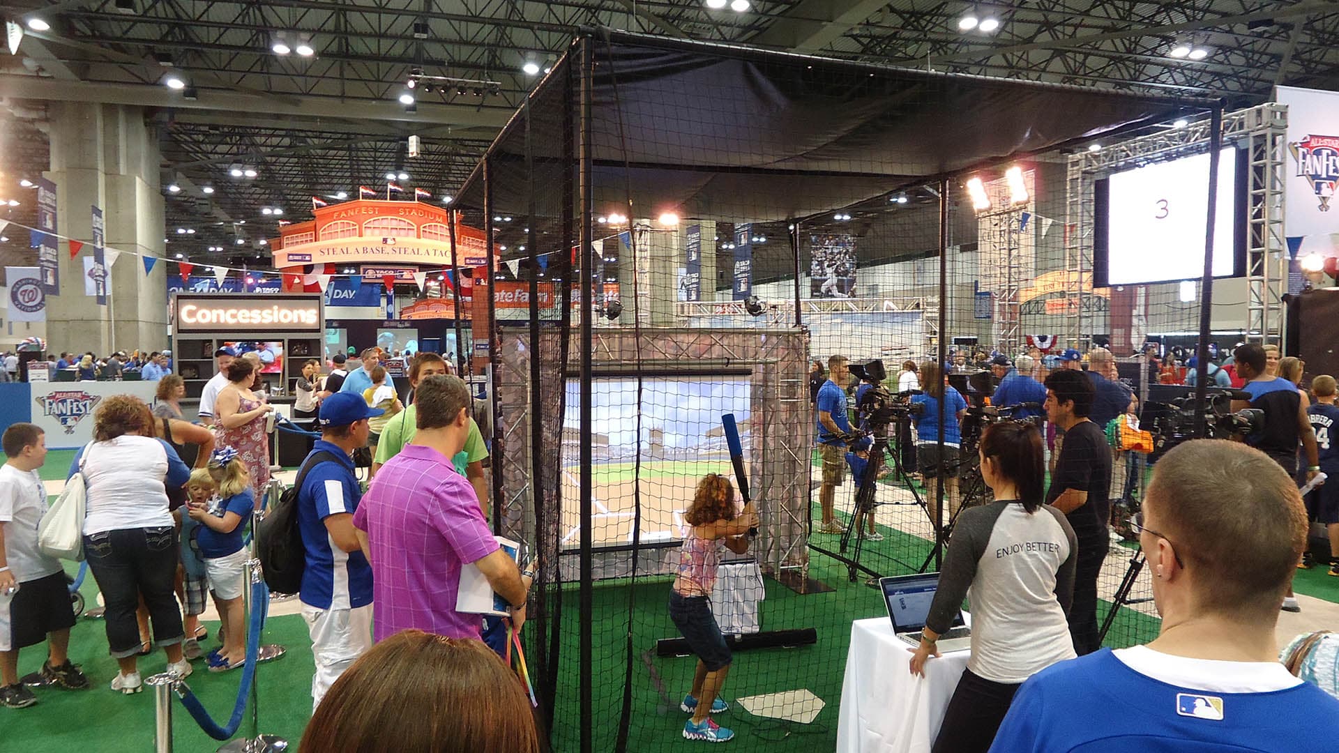A young child takes a turn in the batters box at the MLB Network booth