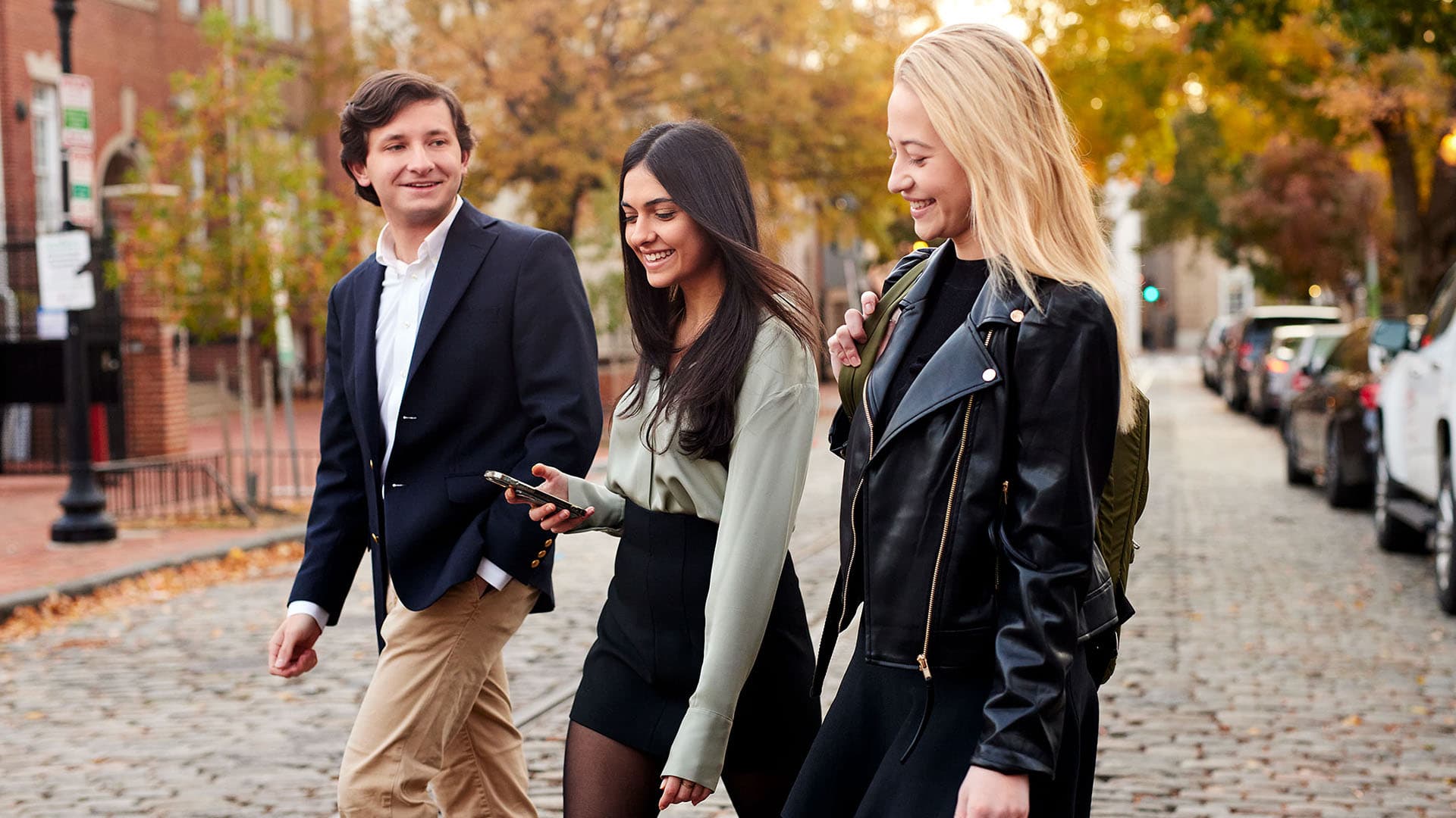Three students walk across campus together
