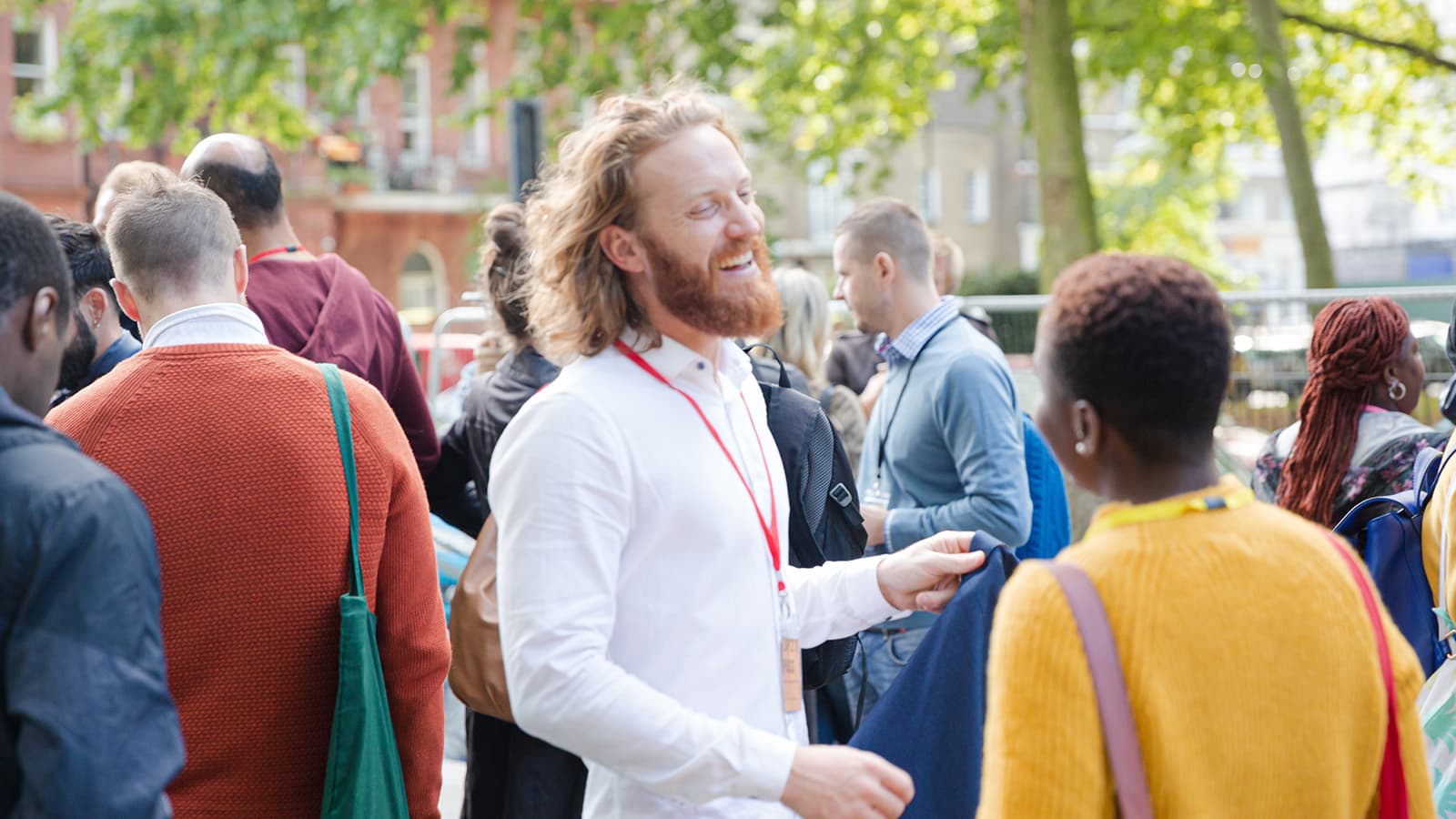 People speaking to each other and laughing in a crowd at an event