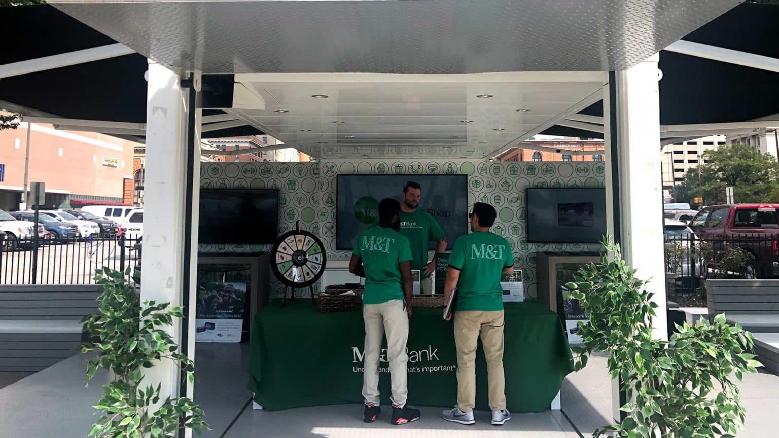 wo people wearing green M&T shirts standing at an M&T table.